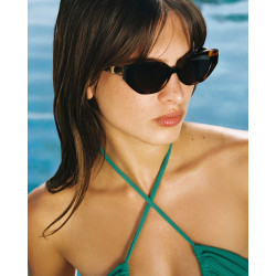 Lunettes de soleil forme papillon monture marron portées par une femme de face